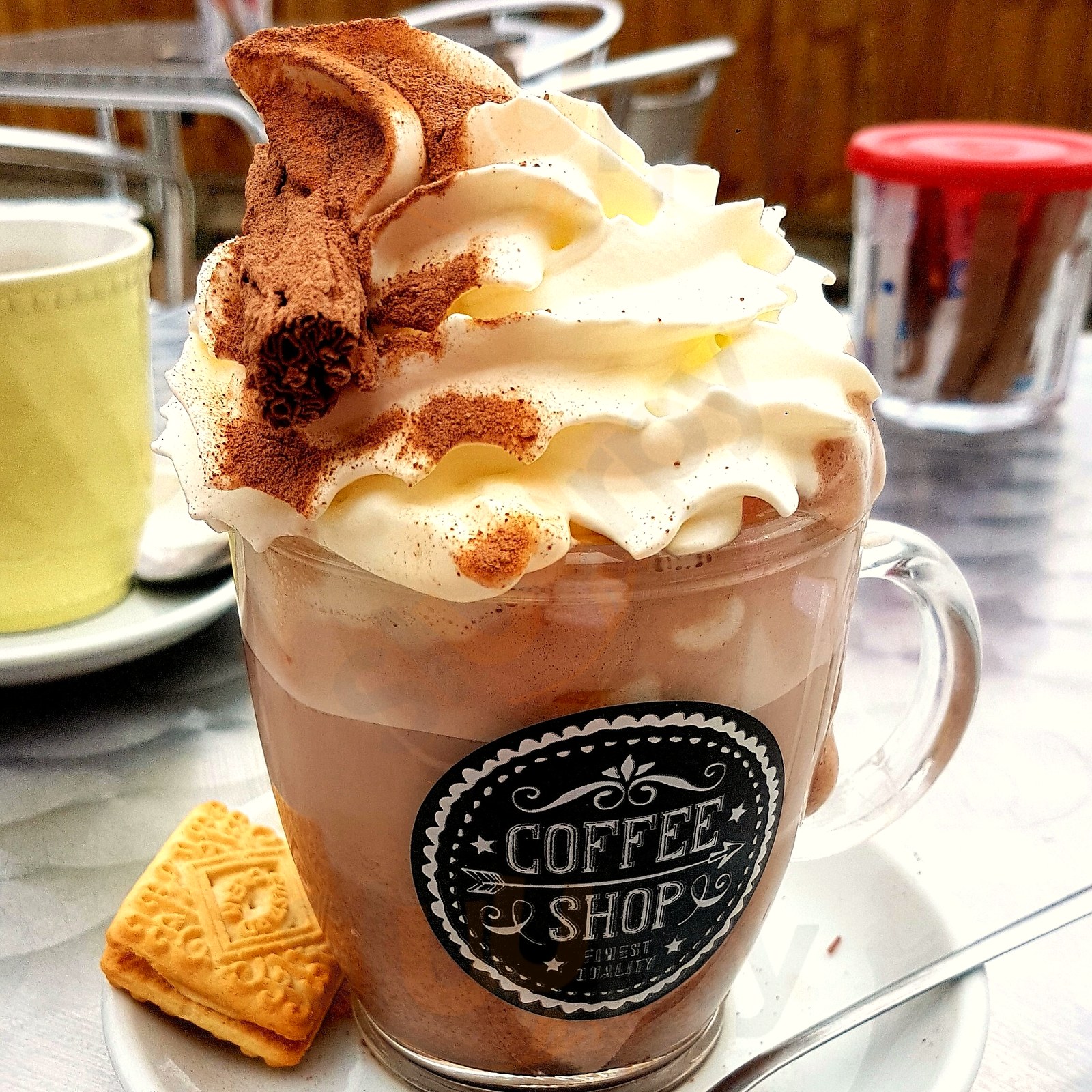 Hot chocolate with whipped cream and a custard cream biscuit
